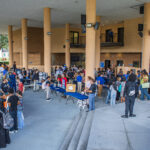 A busy outdoor Club Rush event at the Nunamann Center, with students visiting numerous organization tables, talking with representatives, and browsing information and activities.